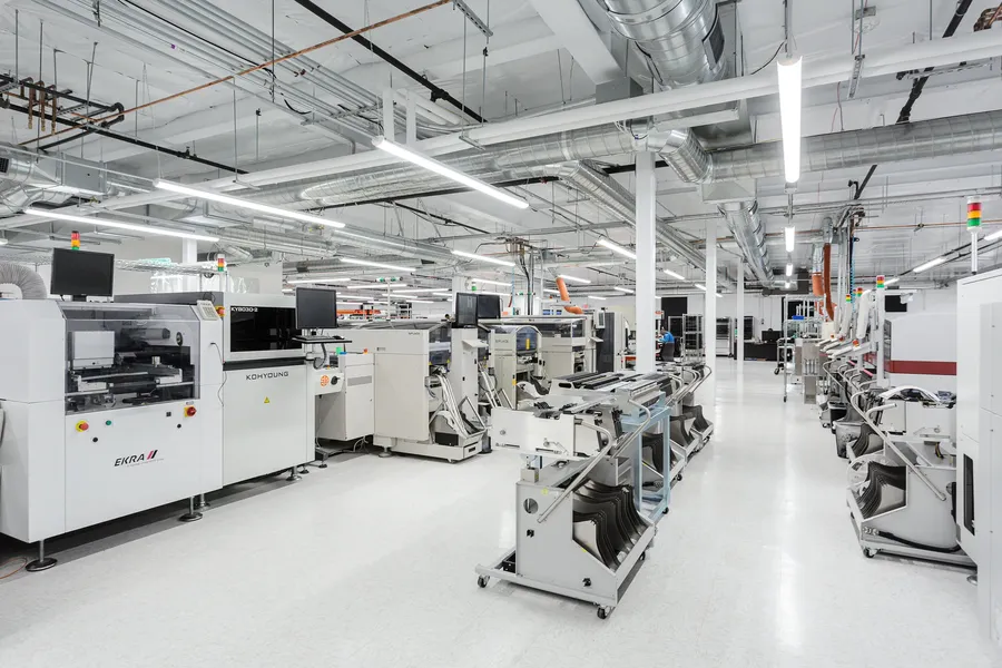 A factory floor with various PCB manufacturing machines in operation.