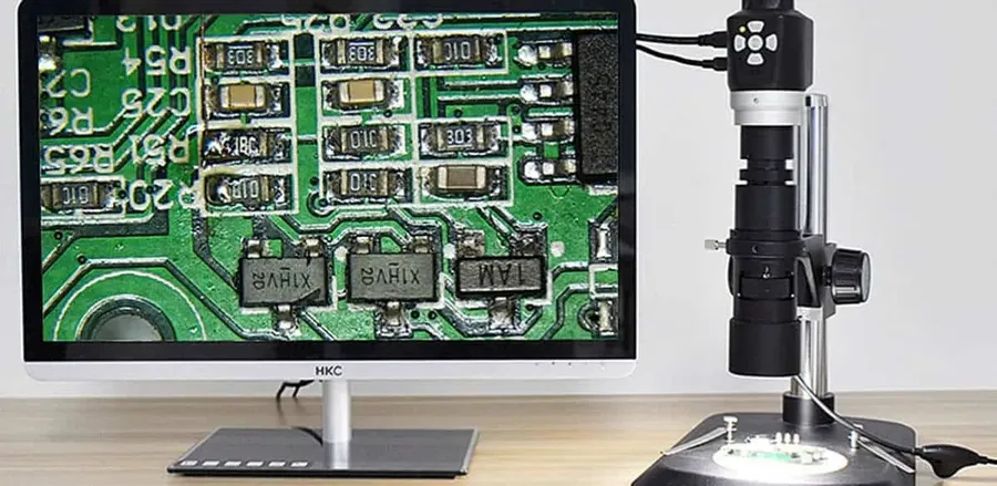 A person inspecting a PCB board with microscope.