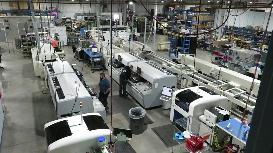 An SMT assembly line in operation, with robots placing components.