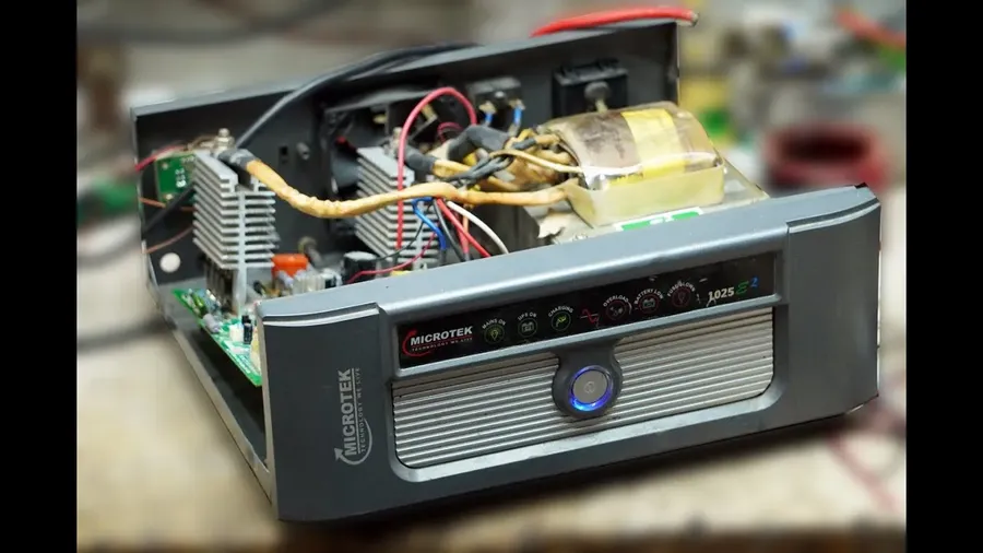Hands performing maintenance on a Microtek inverter.