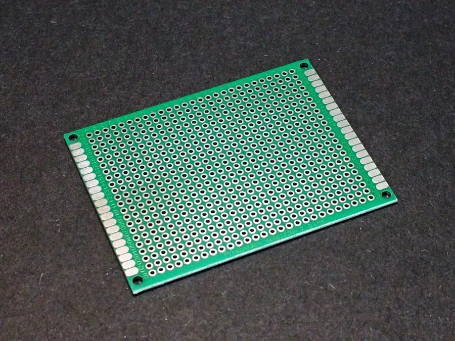 A close-up view of a universal PCB board with various components.
