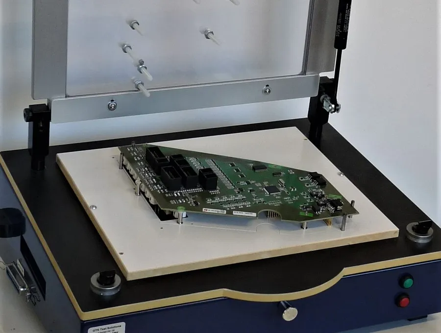 A circuit board being tested with testing equipment.