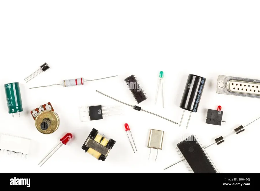A selection of resistors, capacitors, and chips on a table.