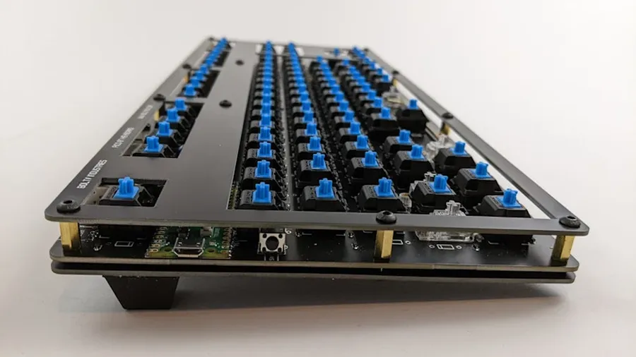 A designer working on a keyboard PCB layout on a computer.