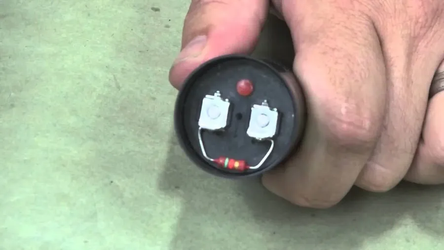Hands replacing a motor capacitor on an electric motor.