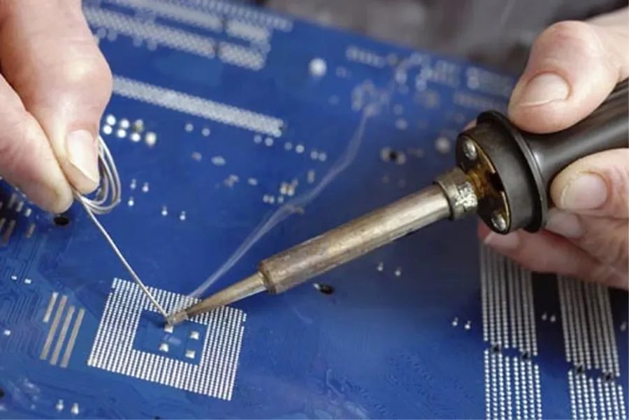 A close-up view of a PCB being soldered.