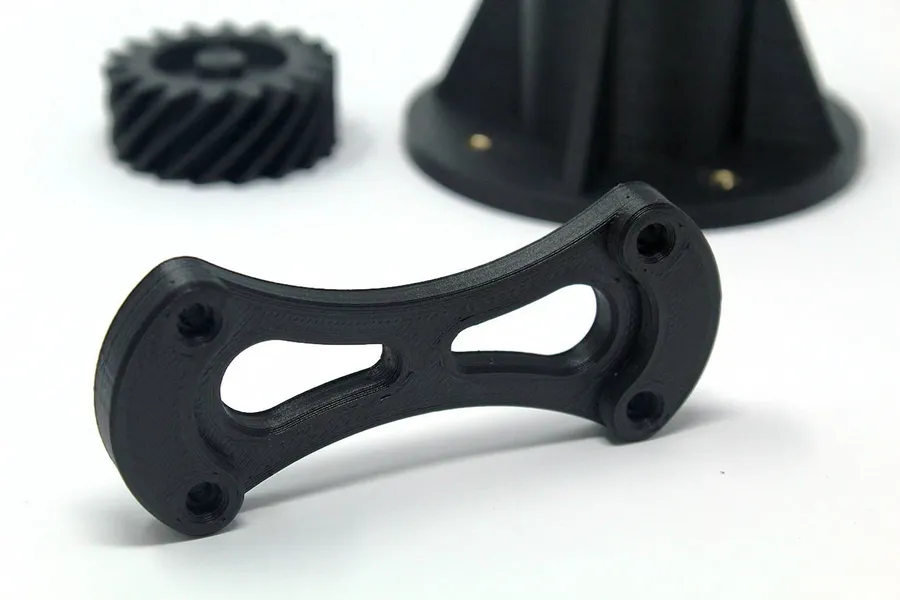 A 3D printer printing a part and example of printed object.