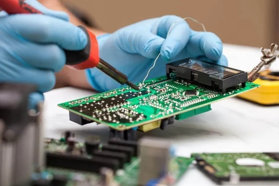 A person hand soldering components onto a PCB.