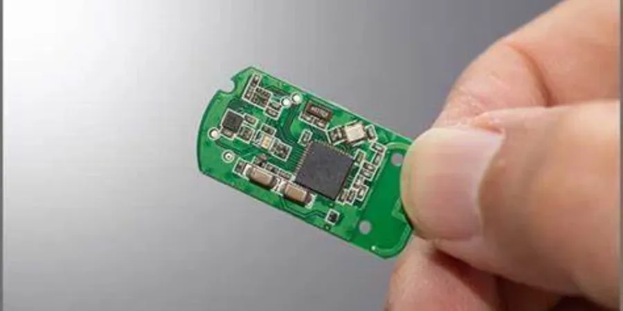 A close-up view of a miniature electronic circuit board, showcasing capacitors used in series for space efficiency.