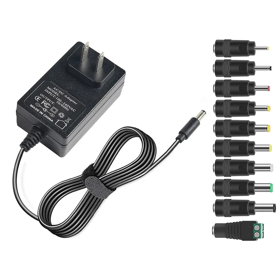 Various batteries and a power adapter on a table.