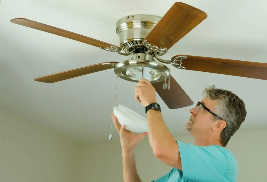 A ceiling fan with blades that are not spinning.