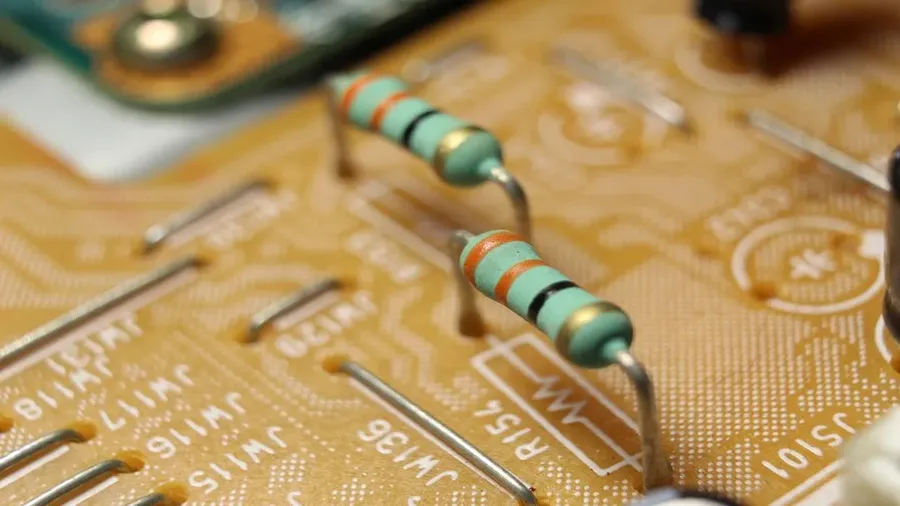 A circuit board with several resistors soldered onto it.