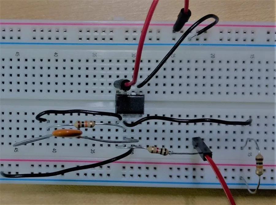 A person using a multimeter to troubleshoot a circuit on a breadboard.