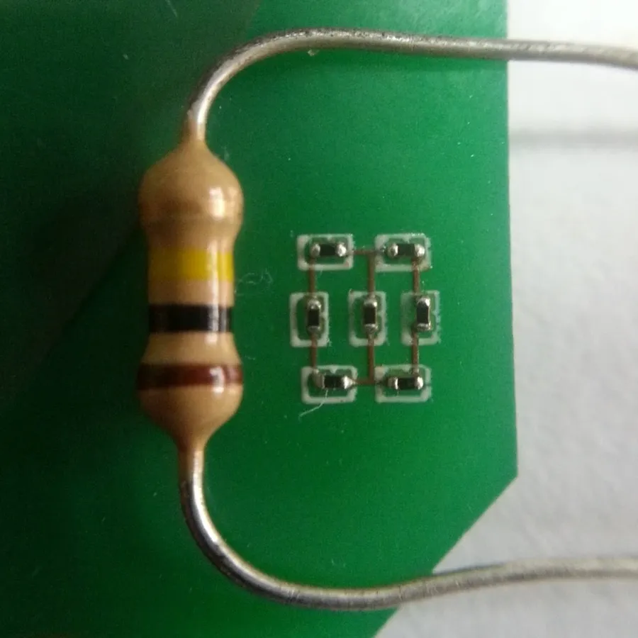 A person soldering a resistor on a circuit board.