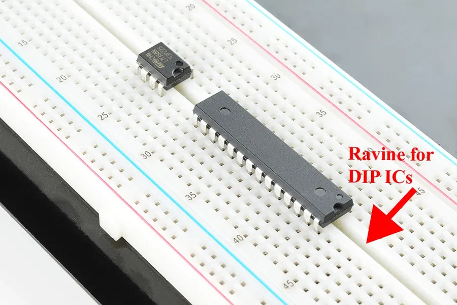 A breadboard with an IC and microcontroller chip wired to various components.