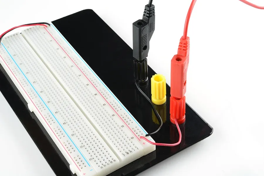 A breadboard powered by a power supply module with connecting wires.