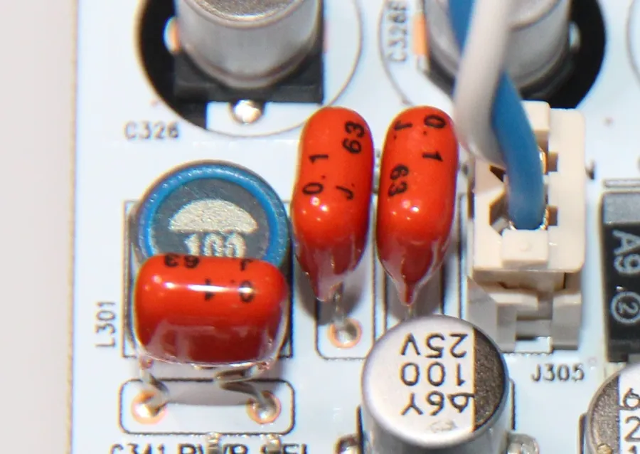 A mylar capacitor soldered on a circuit board.