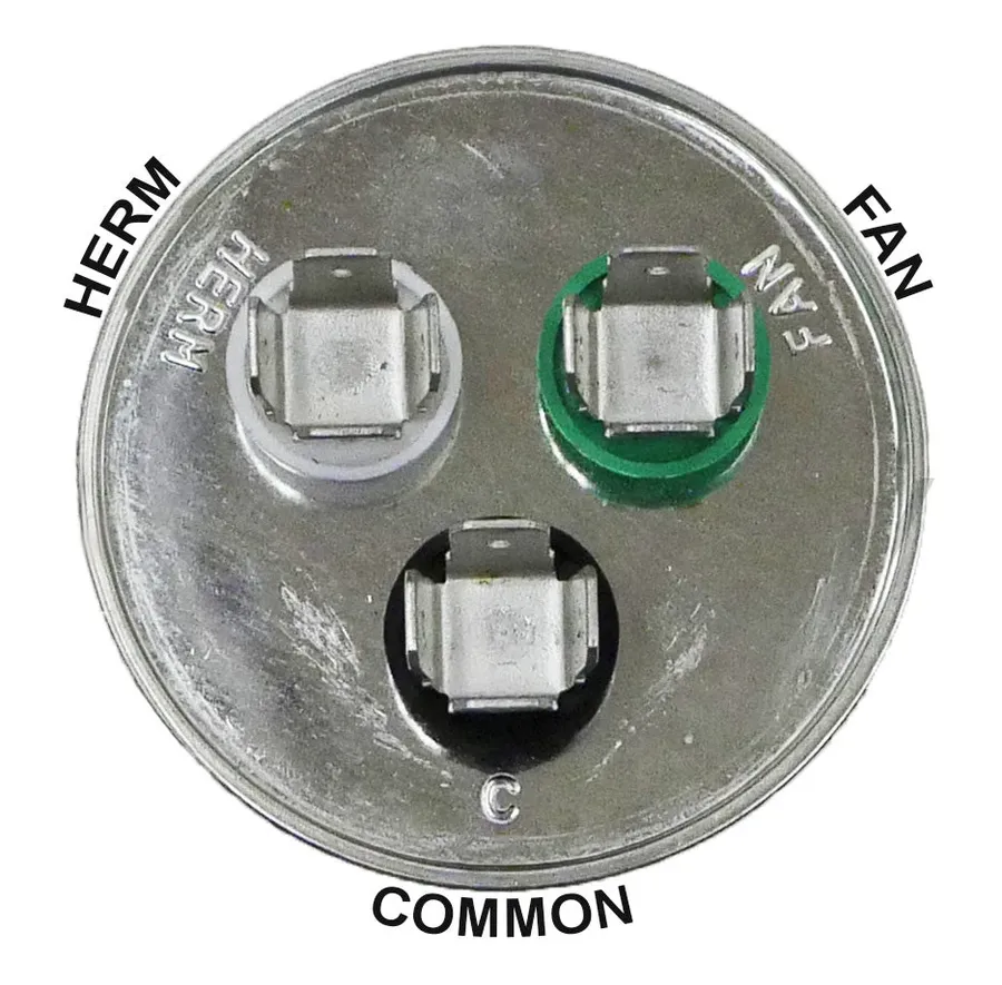 Hands replacing a dual run capacitor in an AC unit.