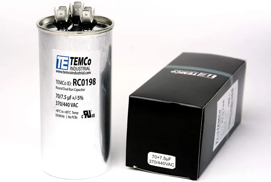 Close-up of a dual run capacitor showing its specification label.