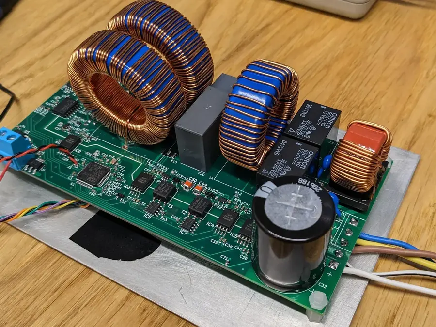 Hands assembling an inverter circuit board with various components