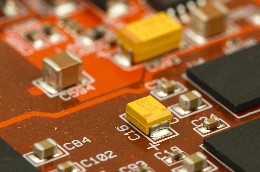 A tantalum capacitor soldered onto a printed circuit board.