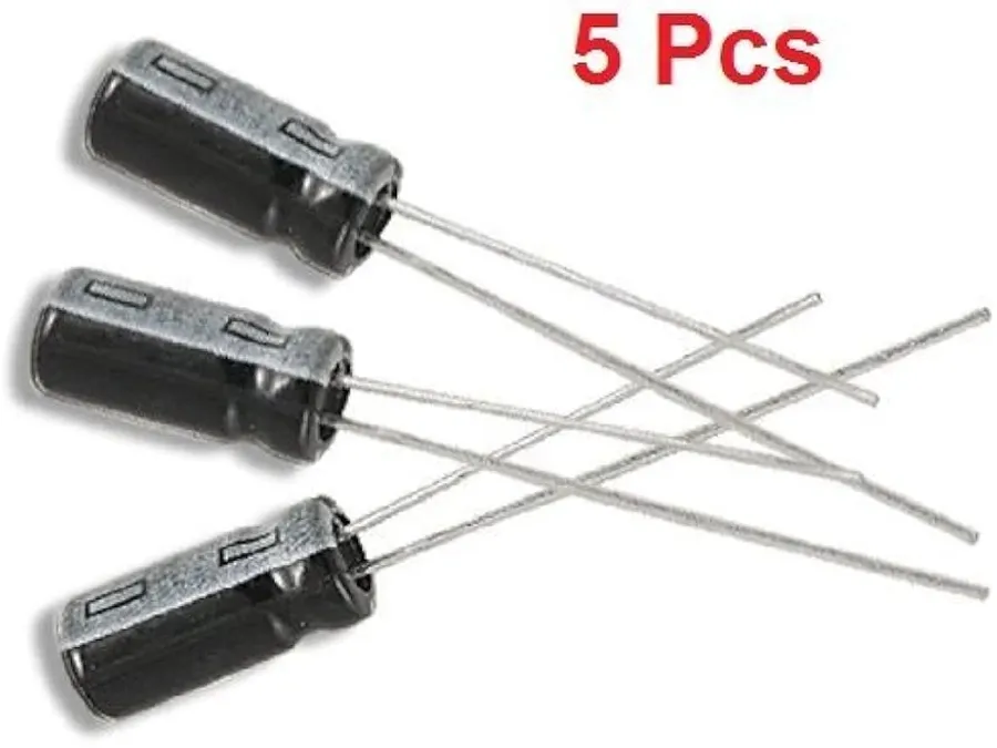 Hands selecting a 47uF capacitor from a tray.