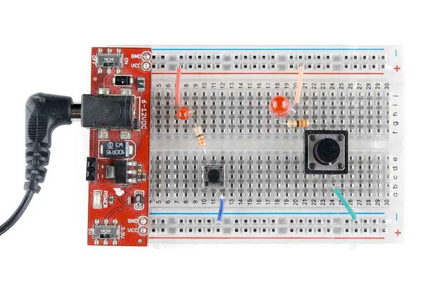 A circuit design transitioning from a breadboard to a finished PCB.