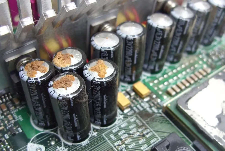 A damaged or blown capacitor on a PCB.