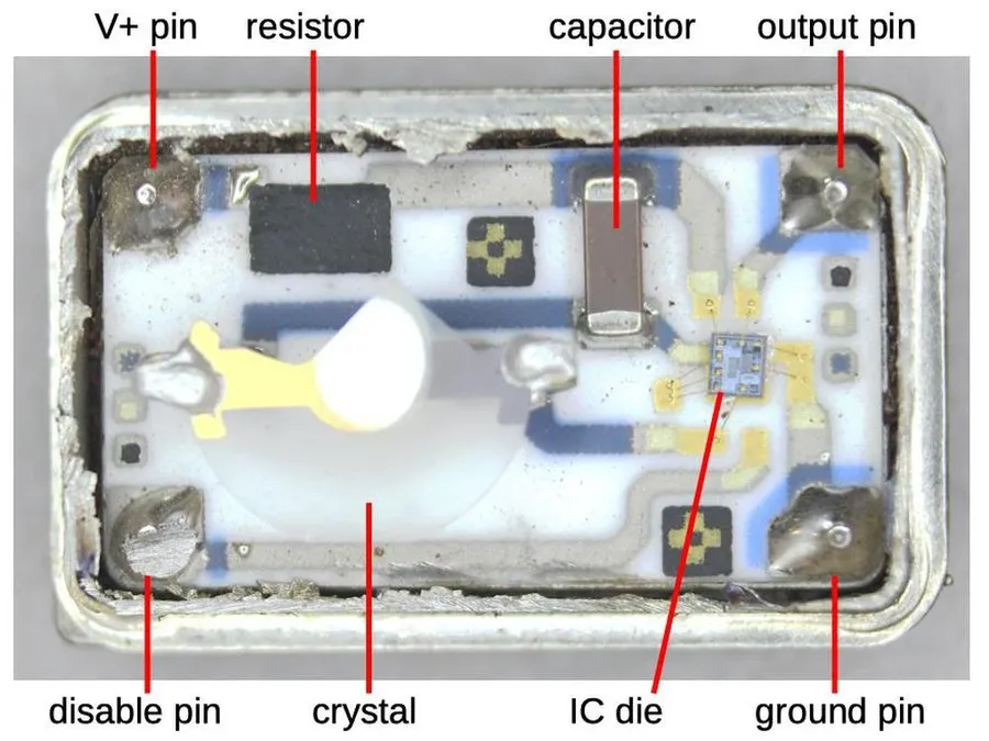 A close up of a PCB with various crystals and oscillators, including cylindrical metal can style and surface mount styles.