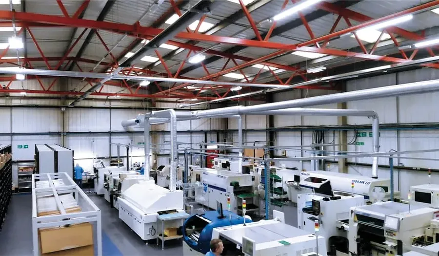 A view of a PCB manufacturing factory with various machines and workers.