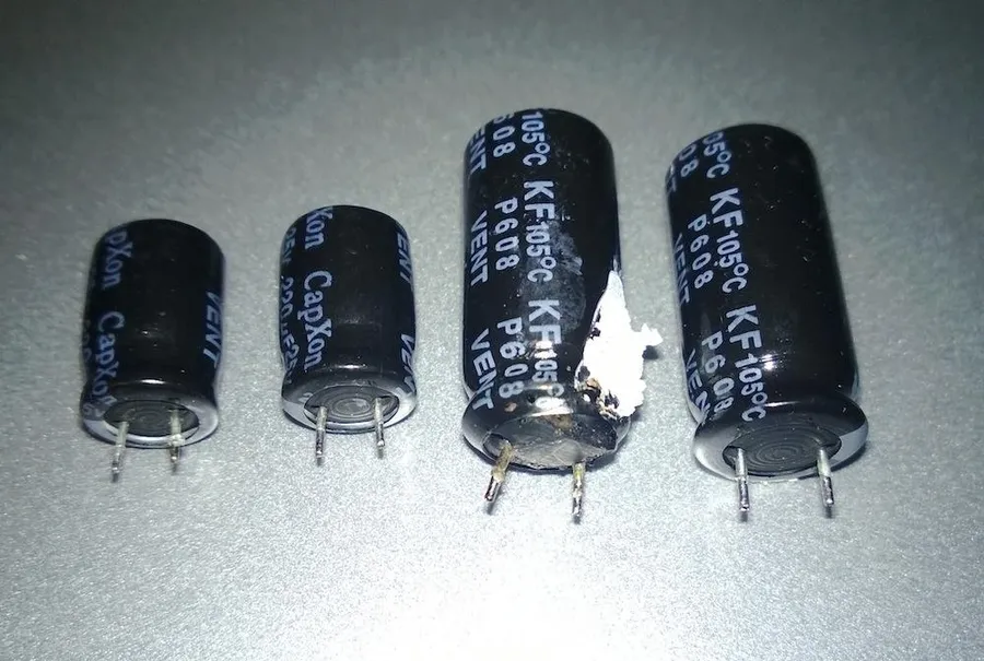 A close-up image of a bulging and damaged capacitor.