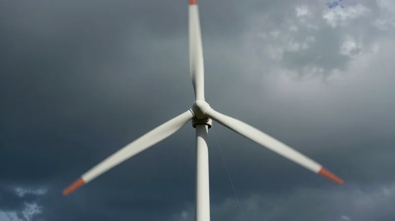 Understanding the Renewable Energy DFM Landscape A close-up view of wind turbine blades in a vast landscape, cinematic atmosphere representing the harsh industrial environment.