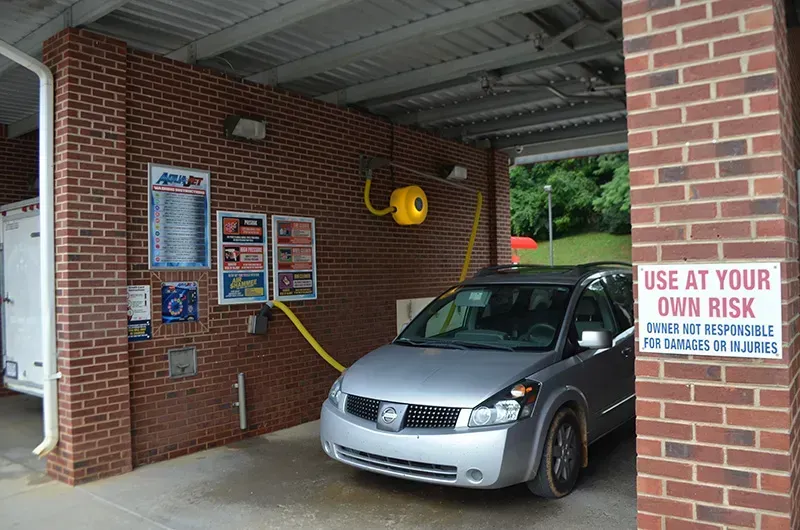 A customer operating a self-service car wash station