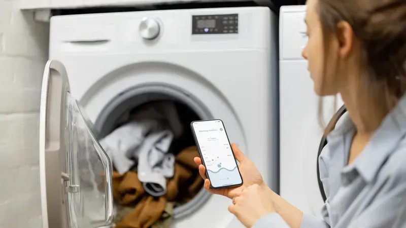 A user's phone displaying an app controlling a smart washing machine