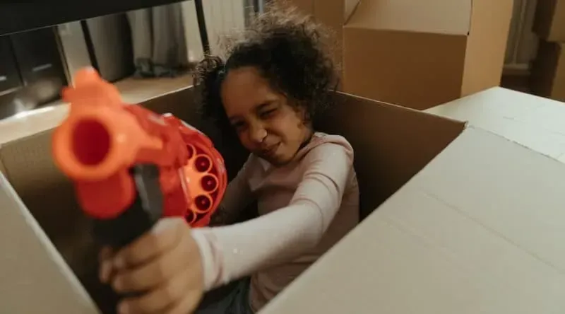 Children retrieving toy guns from a shared toy gun cabinet in a community setting