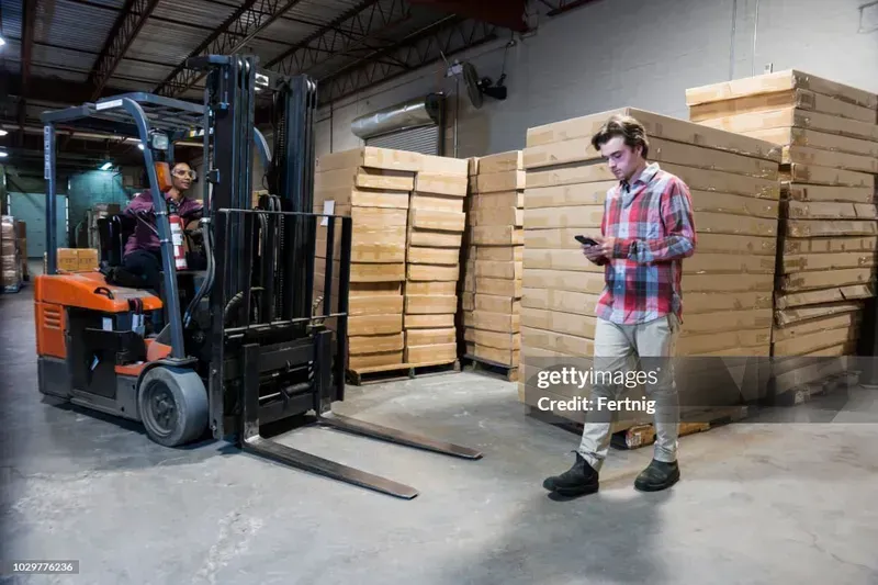 A warehouse worker using a shared mobile phone