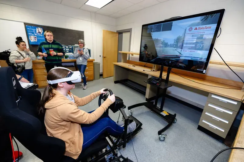 A student practicing driving in a simulator