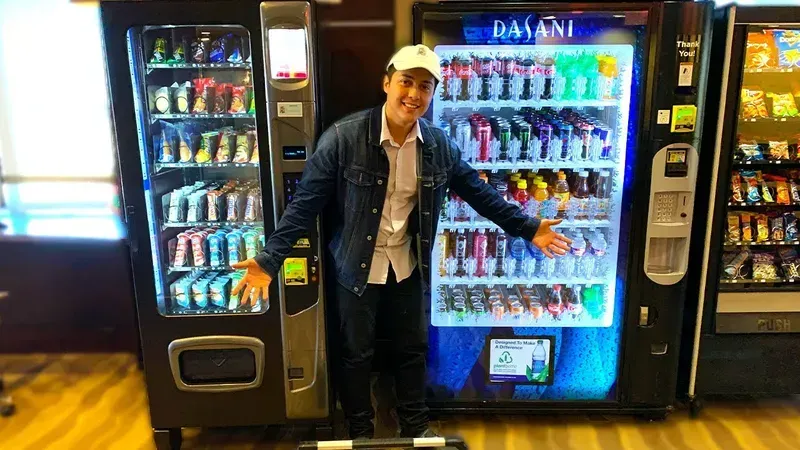 A customer using a cashless payment system on a smart vending machine in a hotel.
