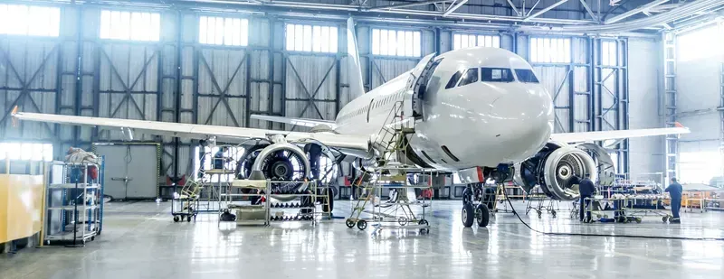 An airplane undergoing maintenance inside a hangar.