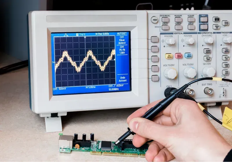 Engineer using equipment to debug a PCB