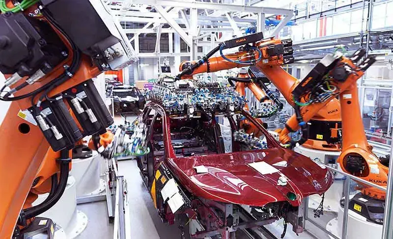 Robots working on an automotive manufacturing assembly line performing quality control or component placement.