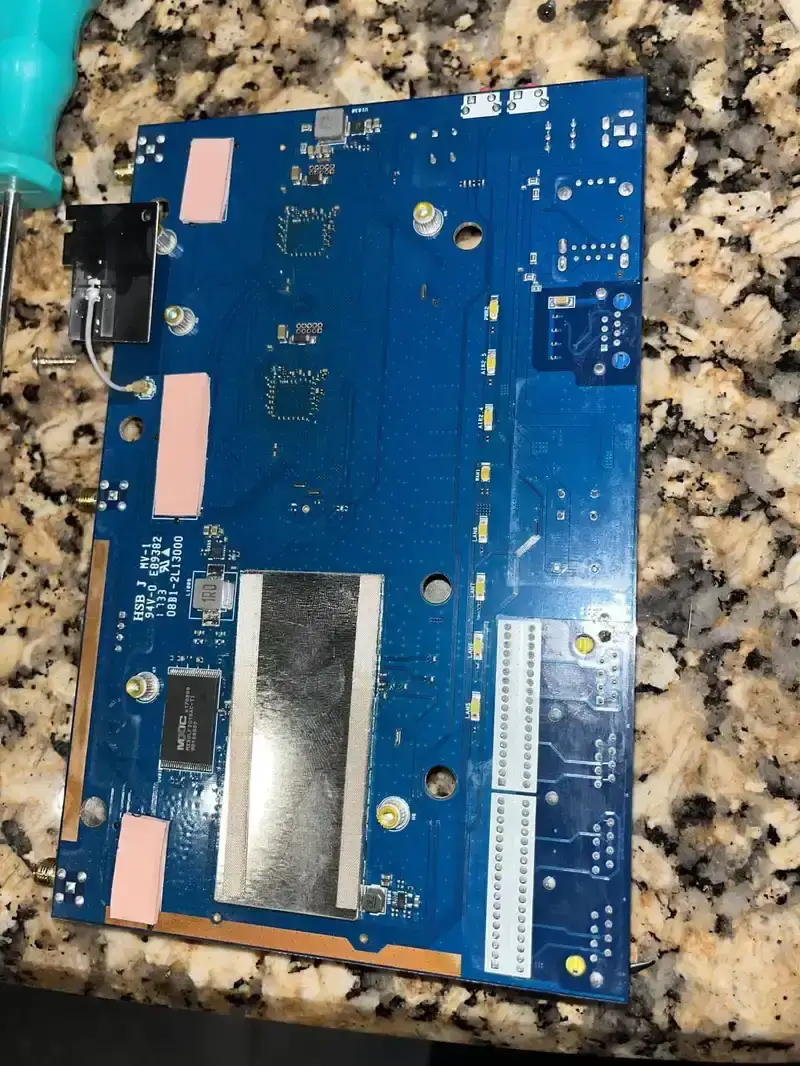 A router motherboard being tested on a specialized testing rig.