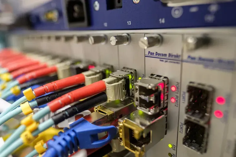 Fiber optic cables connected to network equipment in a server room