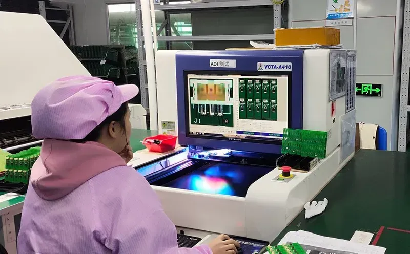 Technicians performing tests on a PCB board using specialized equipment