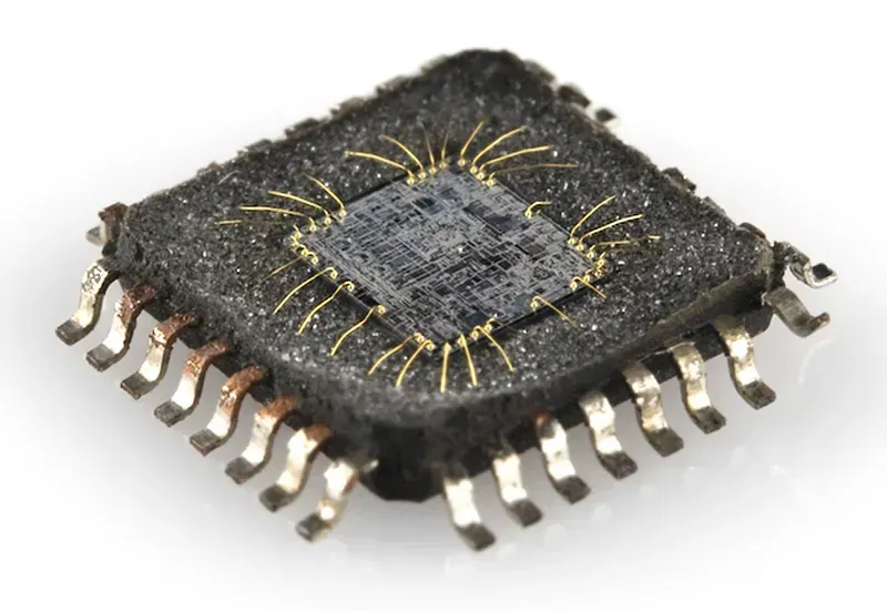 A close-up image of an integrated circuit chip, highlighting its intricate design and pins.