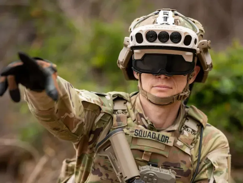 A close-up image of a soldier wearing modern communication equipment on their uniform or helmet.