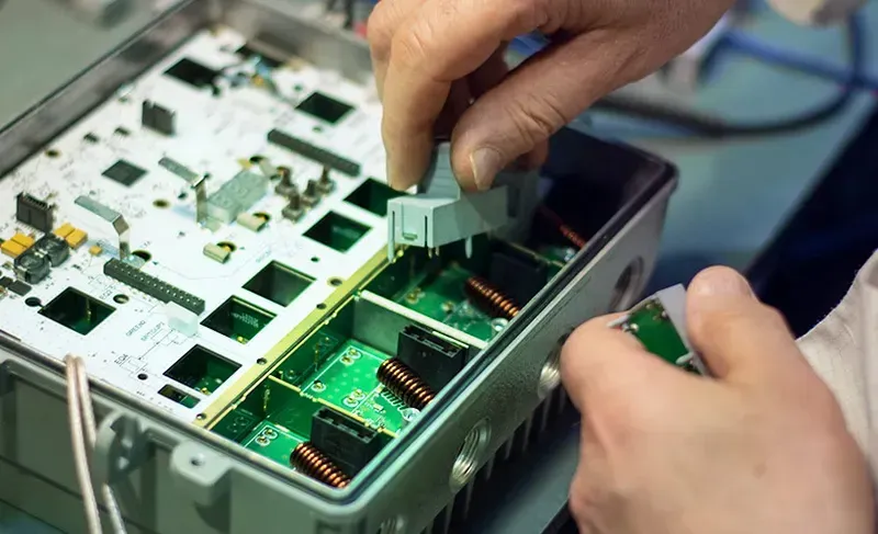 Hands working on a rapid prototyping board for electronics
